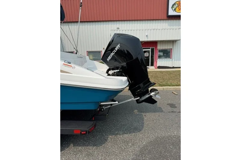Slide: The Image of 2026 Tahoe 2150 CC boat with Mercury outboard motor, parked outside a building. - 21