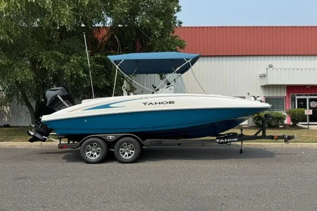 The Image of 2026 Tahoe 2150 CC boat on trailer, blue and white design, parked outdoors. - 0