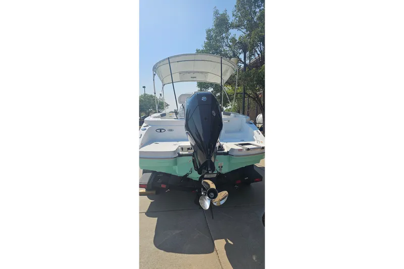 Slide: The Image of 2026 Tahoe 2150 CC boat with outboard motor, parked on a trailer. - 2
