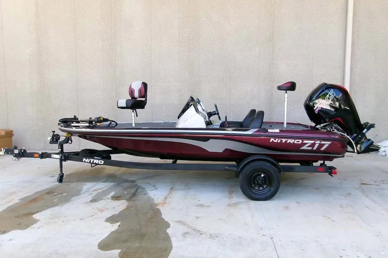 The Image of 2027 Nitro Z17 fishing boat on trailer, side view, maroon and black design. - 0