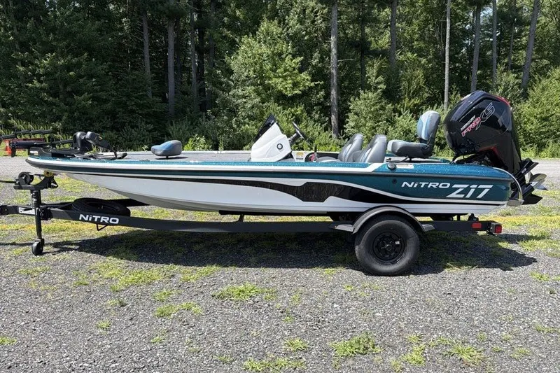 Slide: The Image of 2027 Nitro Z17 boat on trailer, parked outdoors with forest background. - 2