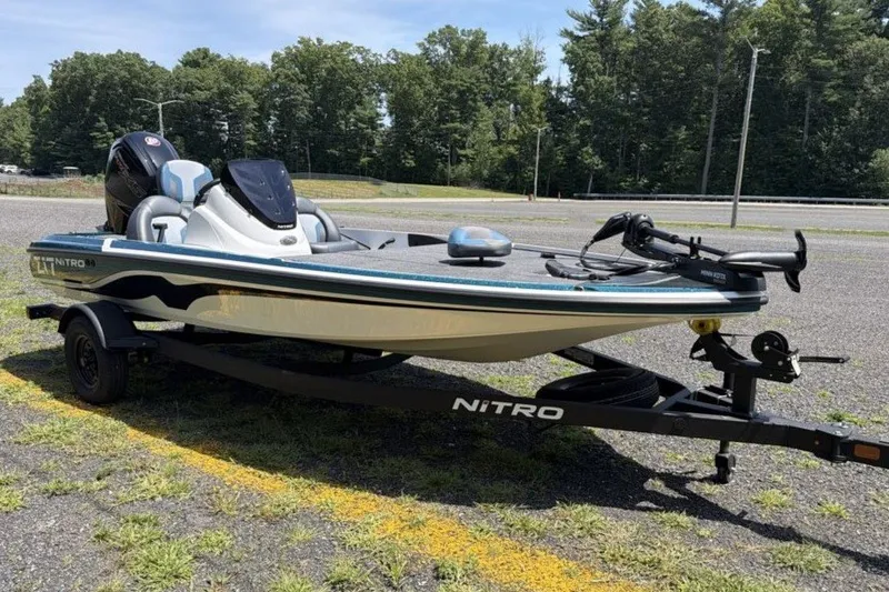 Slide: The Image of 2027 Nitro Z17 boat on trailer in parking lot, surrounded by trees. - 1