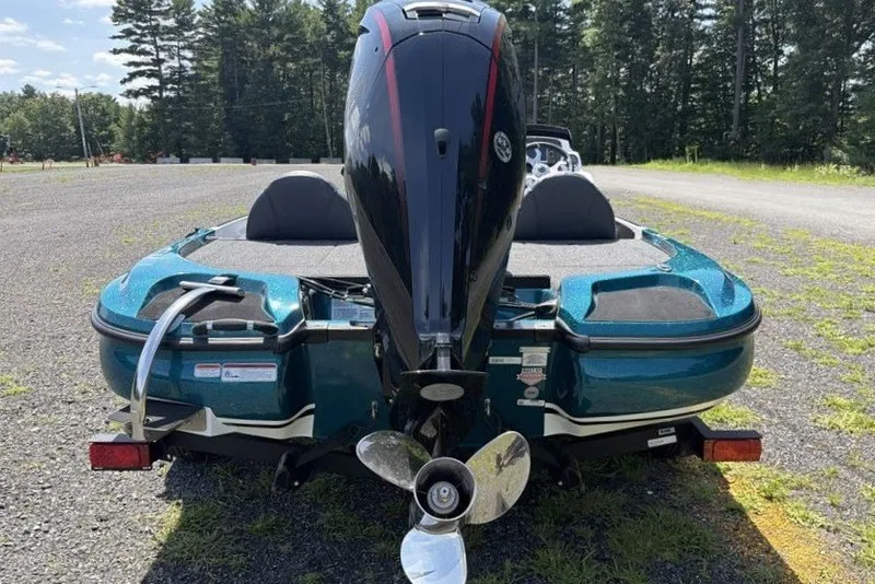 Slide: The Image of 2027 Nitro Z17 boat with powerful outboard motor, parked on gravel near trees. - 6