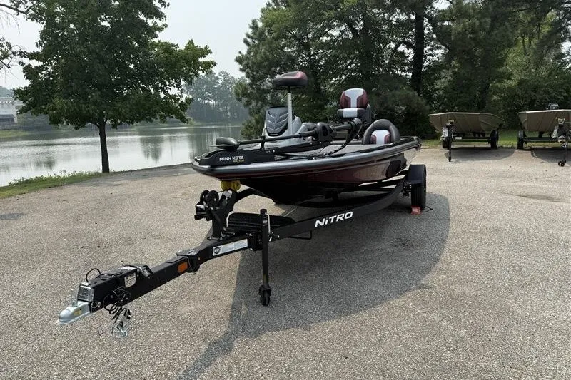 Slide: The Image of 2027 Nitro Z17 boat on trailer near a lake, surrounded by trees. - 1