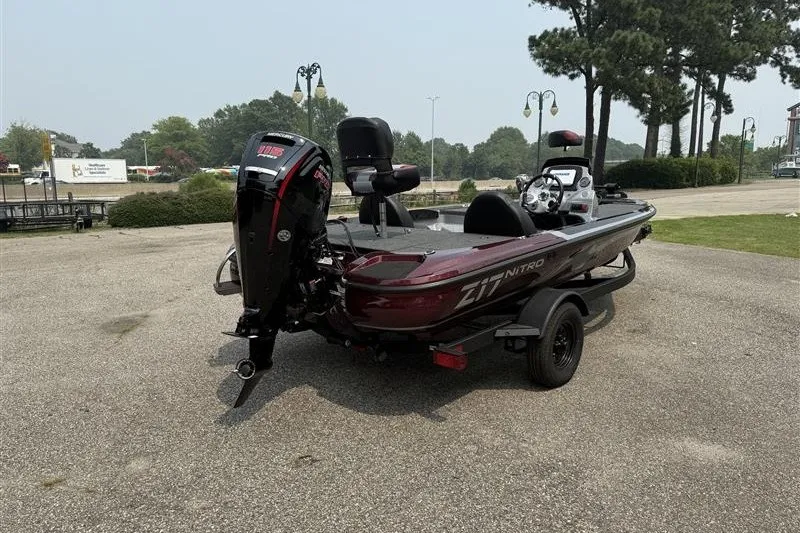 Slide: The Image of 2027 Nitro Z17 boat on trailer, parked outdoors with trees in background. - 4