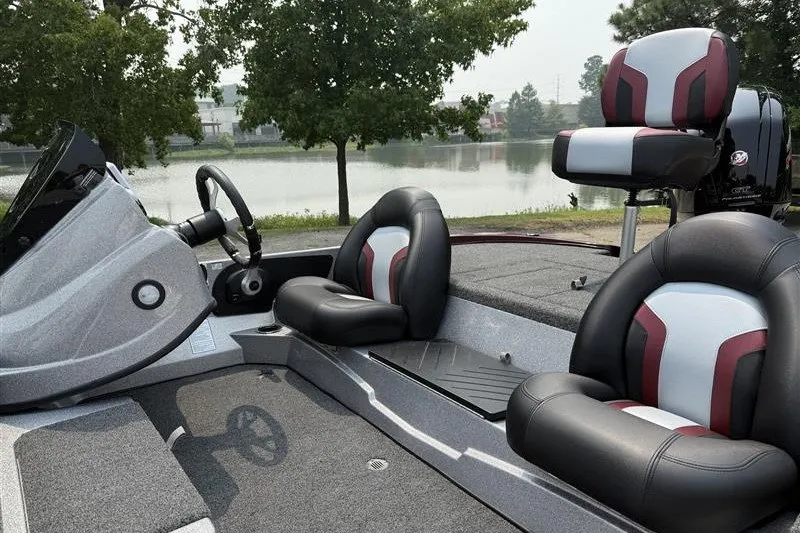 Slide: The Image of 2027 Nitro Z17 boat interior with sleek seating and steering, near a serene lake. - 9