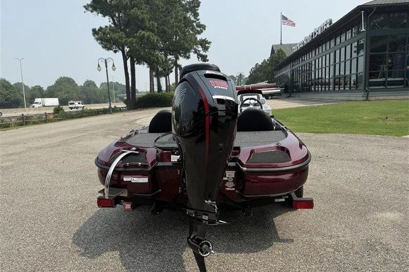 Slide: The Image of Rear view of a 2027 Nitro Z17 boat with an outboard motor, parked outdoors. - 6
