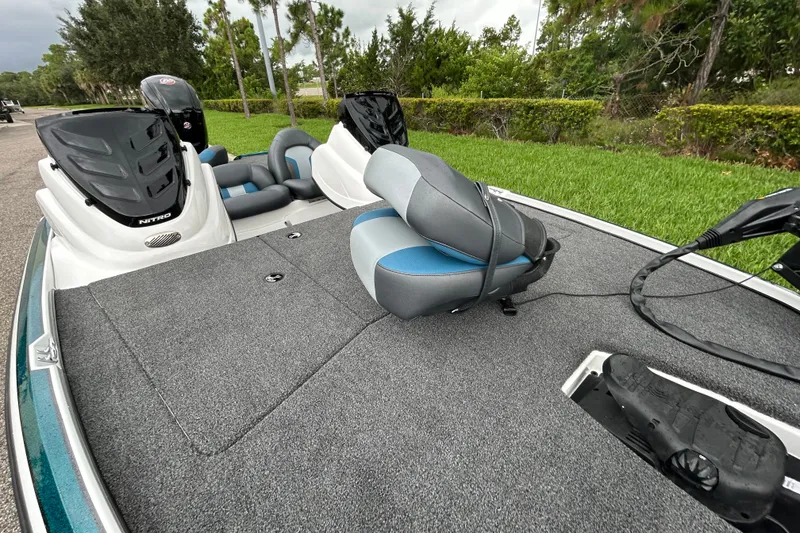 Slide: The Image of 2027 Nitro Z17 boat with gray and blue seating, parked on a grassy area. - 9