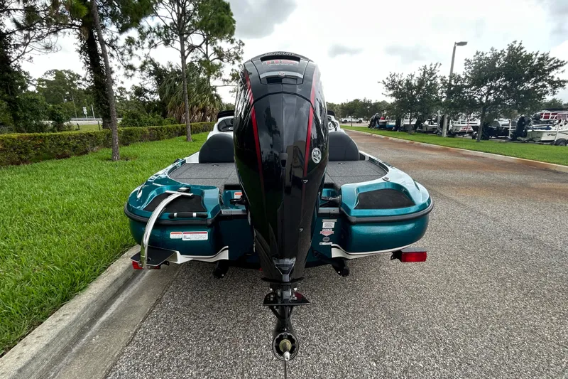 Slide: The Image of Rear view of a 2027 Nitro Z17 boat with an outboard motor on a road. - 2