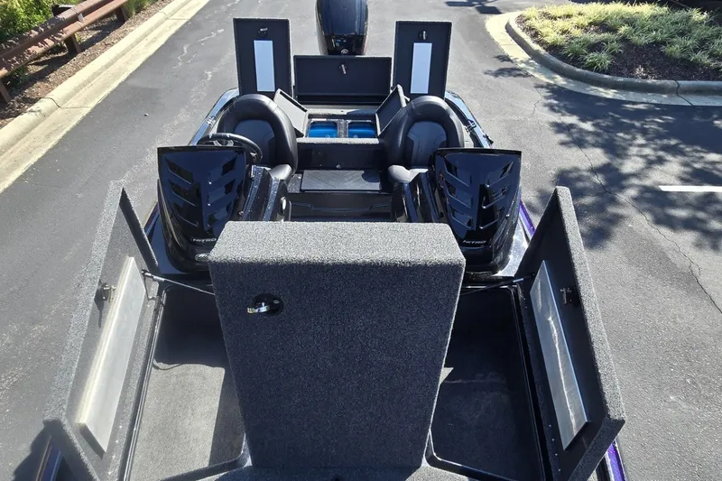 Slide: The Image of 2027 Nitro Z17 boat with open storage compartments and dual seats, parked on asphalt. - 2