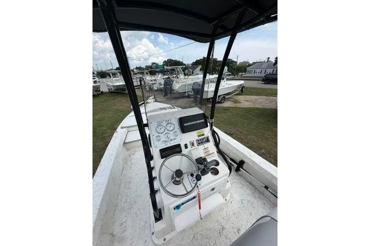 Slide: The Image of 2018 Key Largo 220 Bay boat dashboard with steering wheel and controls, parked outdoors. - 27