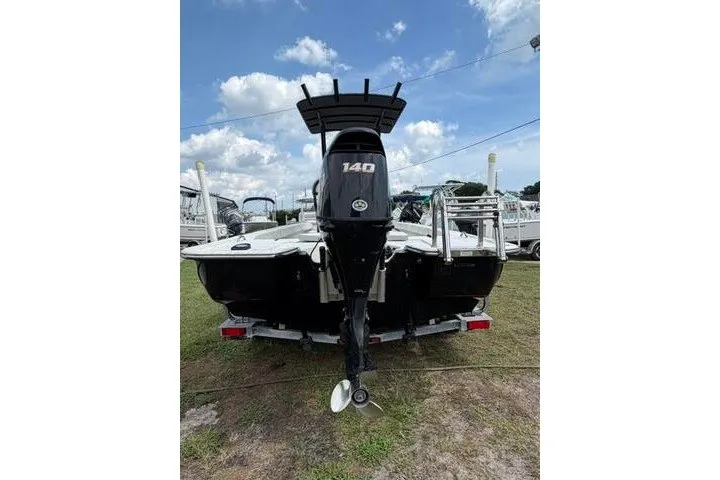 Slide: The Image of 2018 Key Largo 220 Bay boat with 140 HP engine on trailer, under blue sky. - 6