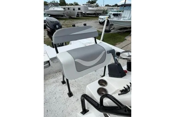 Slide: The Image of 2018 Key Largo 220 Bay boat seat with gray and white upholstery, docked among other boats. - 15