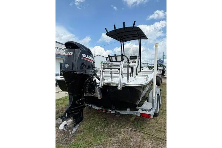 Slide: The Image of 2018 Key Largo 220 Bay boat with Suzuki outboard motor on trailer, under blue sky. - 7