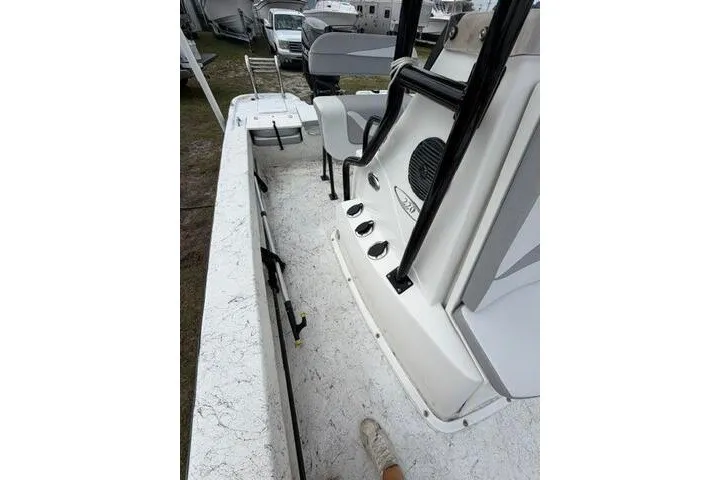 Slide: The Image of 2018 Key Largo 220 Bay boat interior with seating and console, parked outdoors. - 13