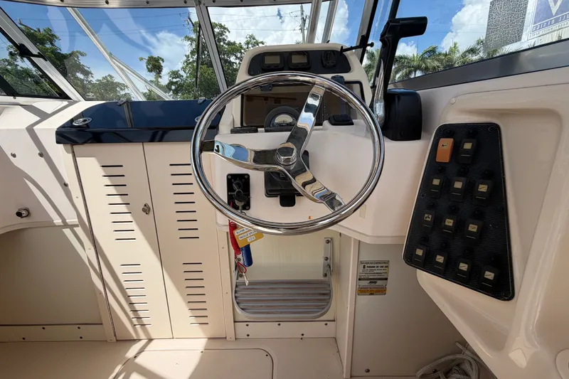 Slide: The Image of 2008 Grady-White Seafarer 226 boat helm with steering wheel and control panel. - 23