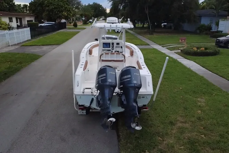 Slide: The Image of 2015 Tidewater 250 CC Adventure boat with dual Yamaha engines on a residential street. - 79