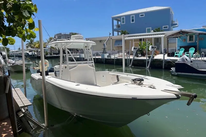 The Image of 2015 Tidewater 250 CC Adventure boat docked in a sunny canal setting. - 4