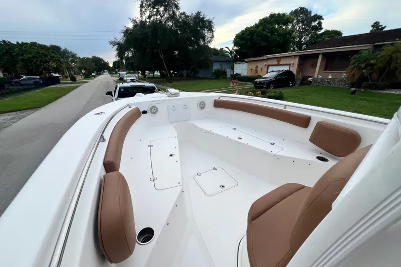 Slide: The Image of 2015 Tidewater 250 CC Adventure boat with tan seating, parked on a residential street. - 62