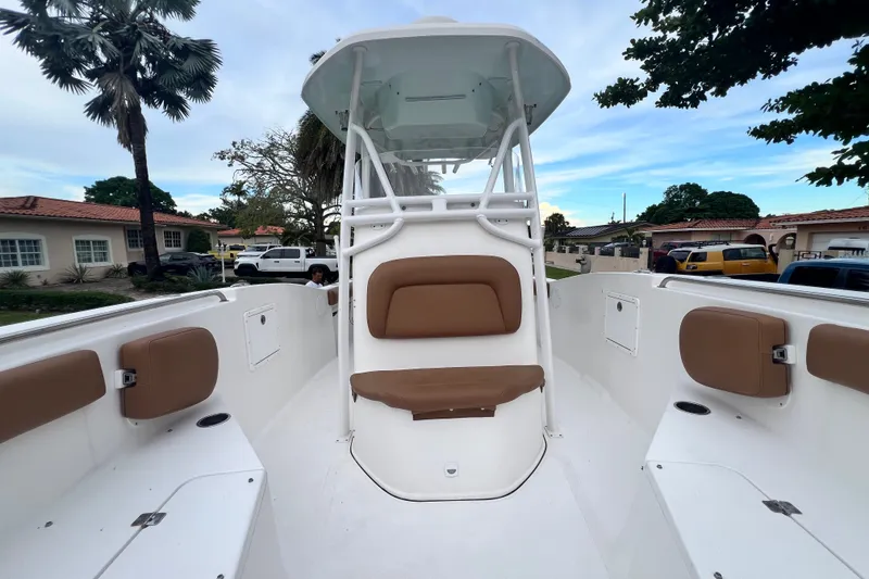 Slide: The Image of 2015 Tidewater 250 CC Adventure boat with tan seating, parked in a residential area. - 56