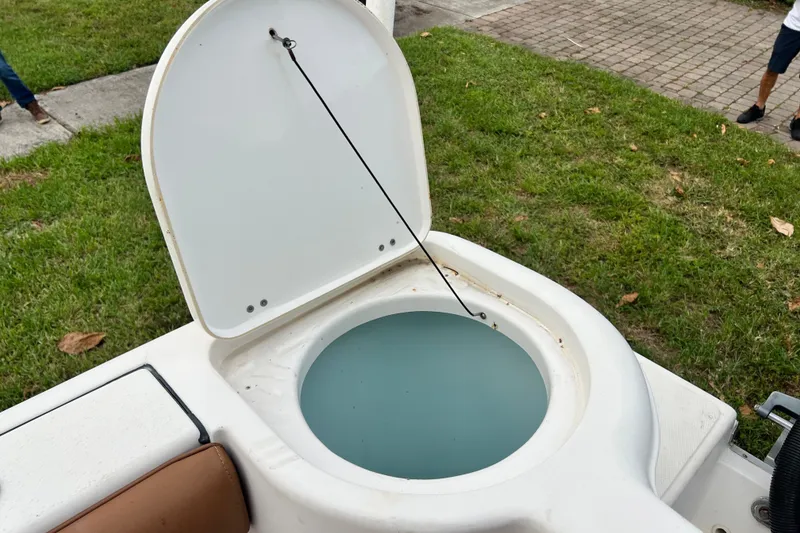 Slide: The Image of Open hatch on 2015 Tidewater 250 CC Adventure boat, revealing a livewell with water. - 24