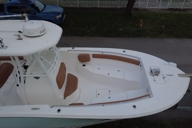 Slide: The Image of 2015 Tidewater 250 CC Adventure boat with white deck and brown seating. - 65