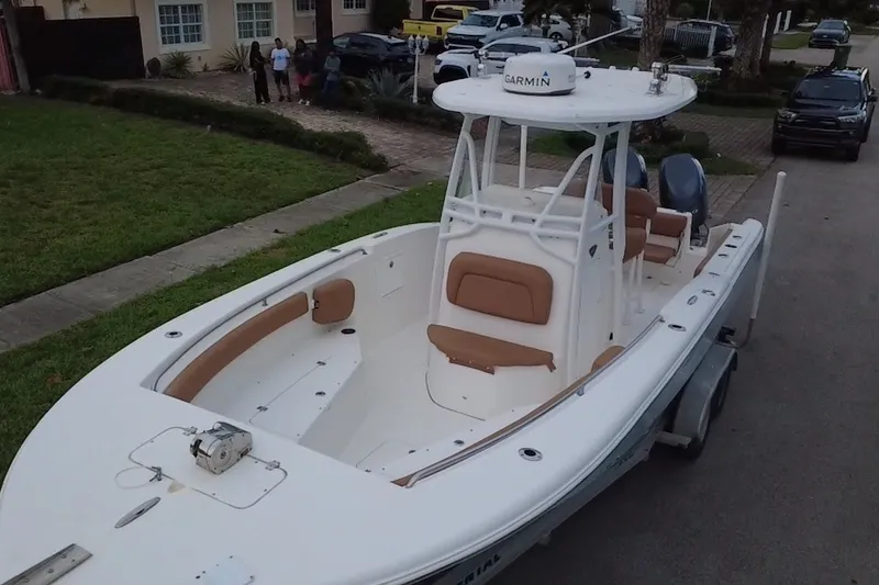 Slide: The Image of 2015 Tidewater 250 CC Adventure boat with Garmin equipment, parked on a residential street. - 73