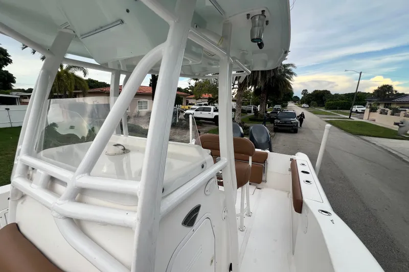Slide: The Image of 2015 Tidewater 250 CC Adventure boat parked on a residential street, showcasing its interior and seating. - 55