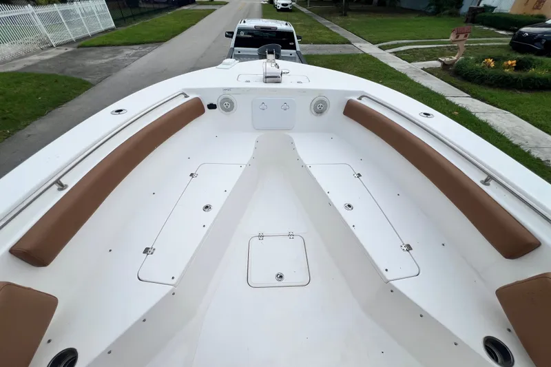 Slide: The Image of 2015 Tidewater 250 CC Adventure boat interior with brown seating and storage compartments. - 61