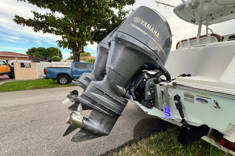 Slide: The Image of 2015 Tidewater 250 CC Adventure with Yamaha outboard motor, parked on a residential street. - 13
