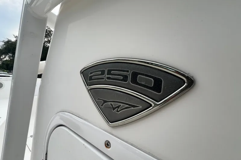 Slide: The Image of 2015 Tidewater 250 CC Adventure boat emblem on white surface. - 52