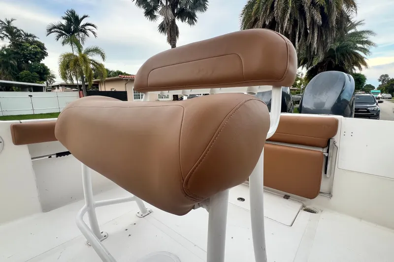 Slide: The Image of Brown leather seating on 2015 Tidewater 250 CC Adventure boat, with palm trees in background. - 35
