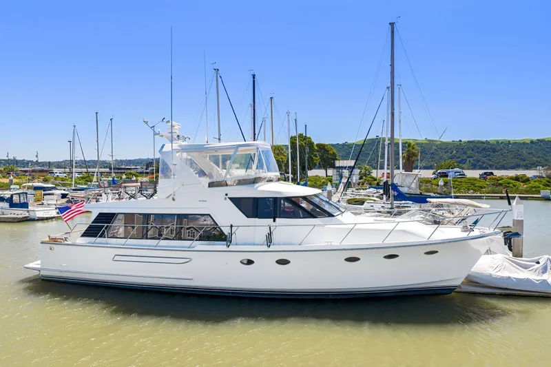 The Image of 1991 Ocean Alexander 520 Pilothouse yacht docked in a marina under clear blue skies. - 0
