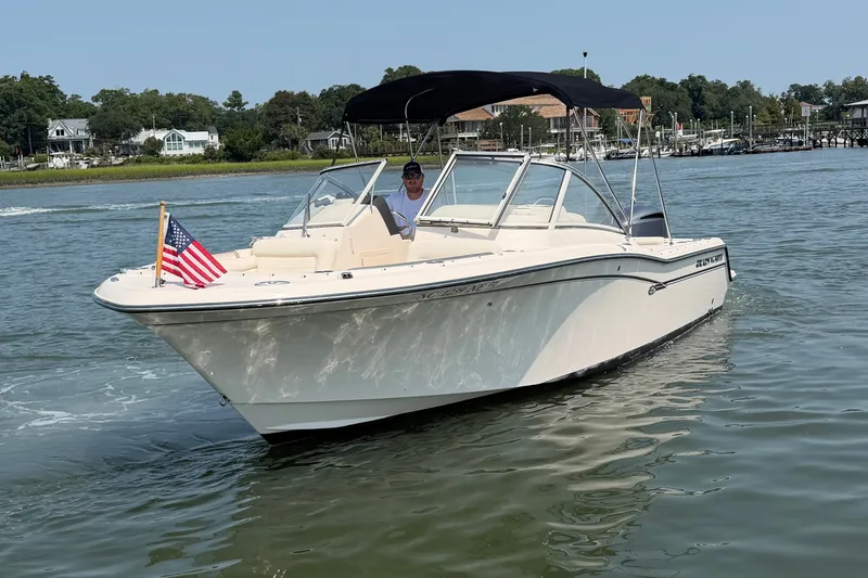 Slide: The Image of 2017 Grady-White Freedom 235 boat cruising on a calm river with American flag. - 11