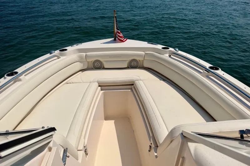Slide: The Image of 2017 Grady-White Freedom 235 boat interior with seating, American flag, and ocean view. - 24