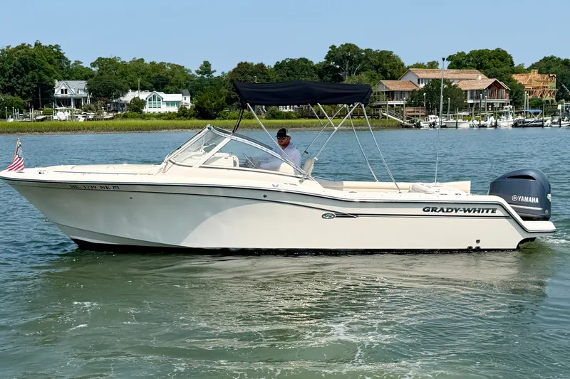 Slide: The Image of 2017 Grady-White Freedom 235 boat cruising on a calm river with scenic background. - 19