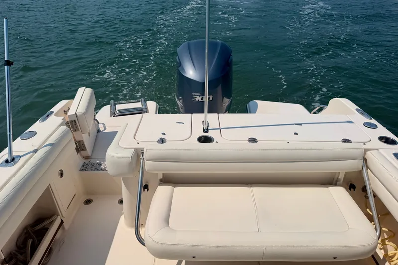 Slide: The Image of 2017 Grady-White Freedom 235 boat interior with seating and outboard motor on water. - 34