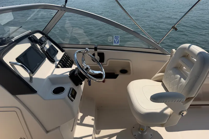 Slide: The Image of 2017 Grady-White Freedom 235 boat cockpit with steering wheel and captain's chair. - 30