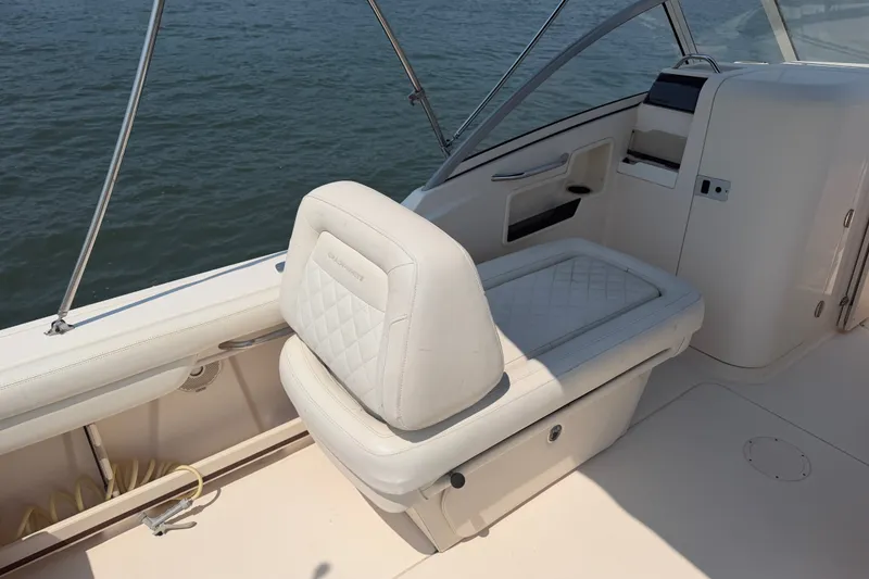 Slide: The Image of 2017 Grady-White Freedom 235 boat interior with cushioned seating by the water. - 36