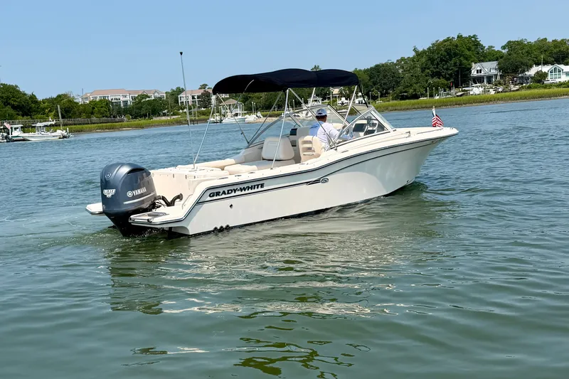 Slide: The Image of 2017 Grady-White Freedom 235 boat cruising on a calm lake with scenic background. - 3