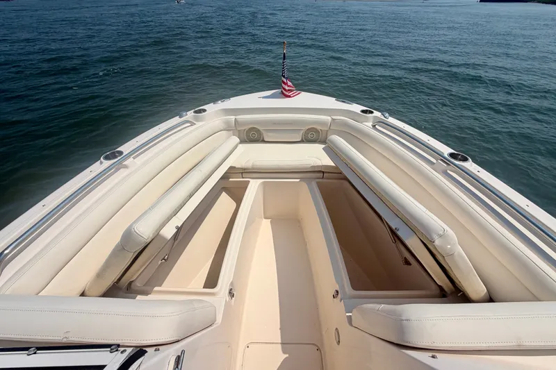 Slide: The Image of 2017 Grady-White Freedom 235 boat interior with seating and storage, on calm water. - 25