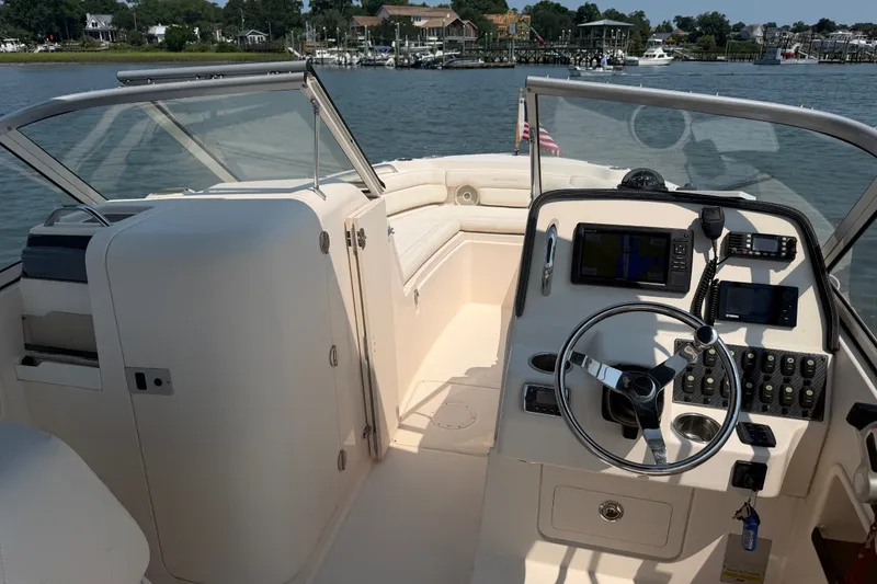 Slide: The Image of 2017 Grady-White Freedom 235 boat interior with steering wheel and control panel. - 33