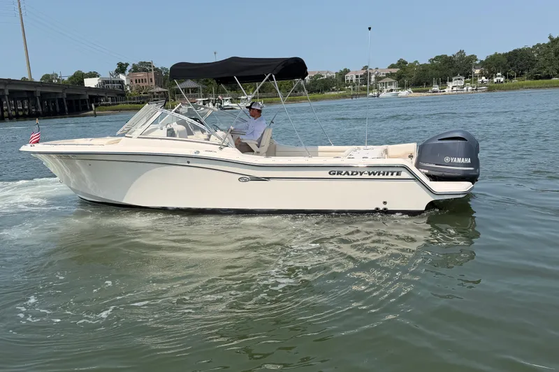 Slide: The Image of 2017 Grady-White Freedom 235 boat cruising on a calm river with a Yamaha engine. - 6