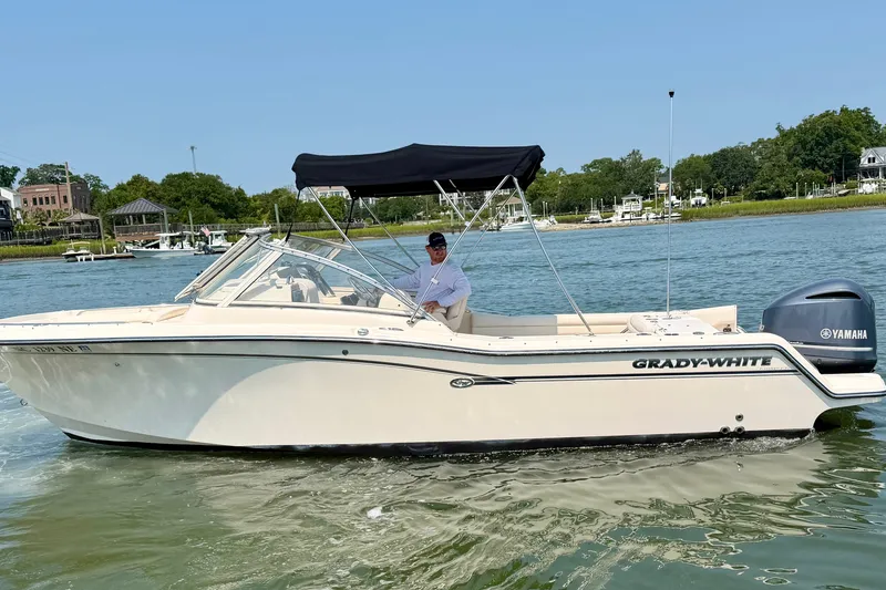 Slide: The Image of 2017 Grady-White Freedom 235 boat on water, featuring Yamaha engine and black canopy. - 7