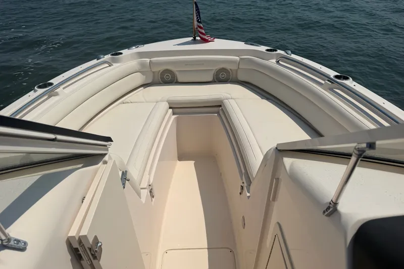 Slide: The Image of 2017 Grady-White Freedom 235 boat interior with seating, on calm water. - 22