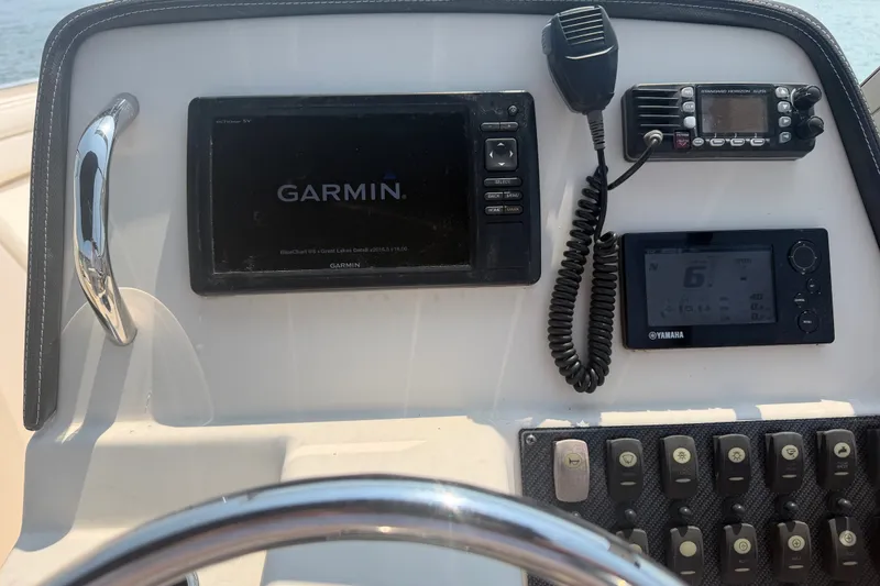 Slide: The Image of Control panel of a 2017 Grady-White Freedom 235 boat with Garmin and Yamaha displays. - 26