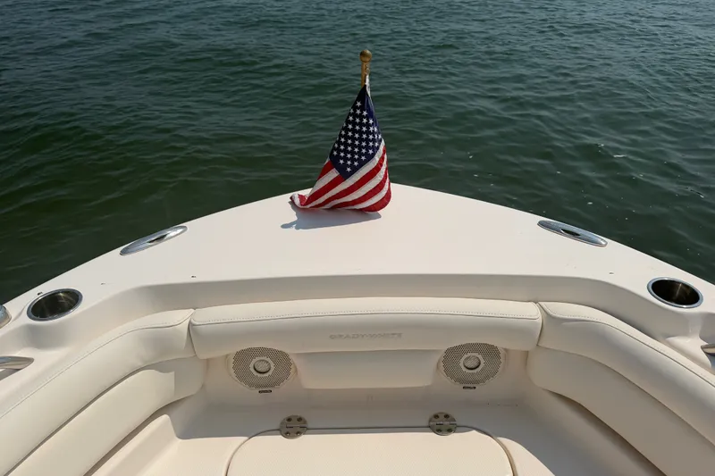 Slide: The Image of 2017 Grady-White Freedom 235 boat with American flag on calm water. - 20
