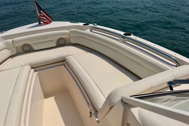 Slide: The Image of 2017 Grady-White Freedom 235 boat interior with seating and American flag on water. - 23