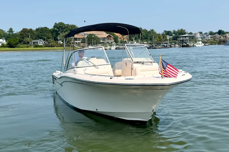 Slide: The Image of 2017 Grady-White Freedom 235 boat on water, American flag, scenic background. - 13