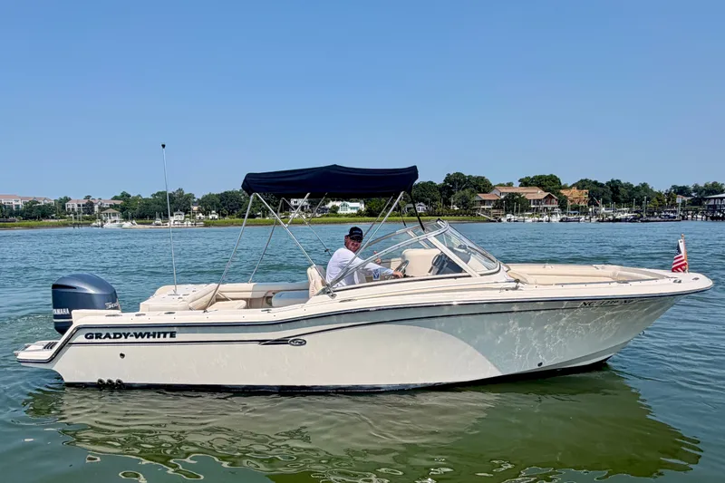 Slide: The Image of 2017 Grady-White Freedom 235 boat on calm water with a scenic background. - 14
